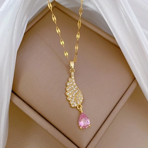 Detailed view of angel wing necklace with pink teardrop stone in jewelry box