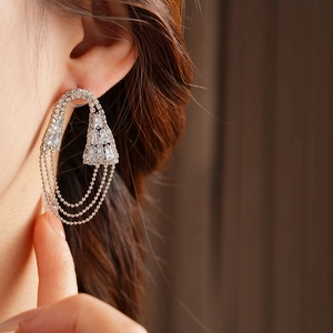 Dettaglio orecchino a nappa in zircone geometrico argento indossato da modella con perle