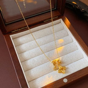 Macro shot of 18k gold plated clover necklace with zircon inlay on a jewelry box