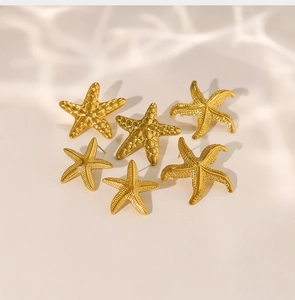 Ensemble de six boucles d'oreilles étoiles de mer dorées avec texture fine sur fond aquatique