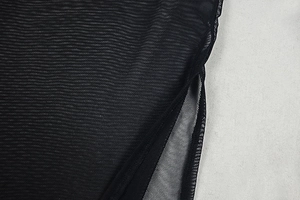 Detailed macro view of sheer black mesh fabric texture and precise seam stitching