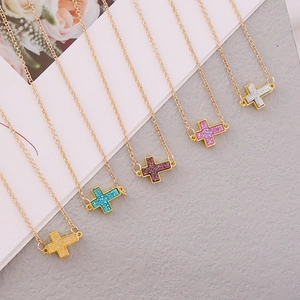Macro shot of colorful cross pendants with glittering finish on golden chains