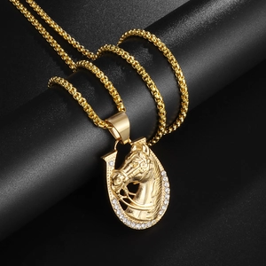 Close-up of gold-plated horse head horseshoe pendant with sparkling rhinestones details
