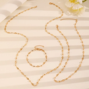 Elegant gold heart link necklace with crystals on a soft beige background