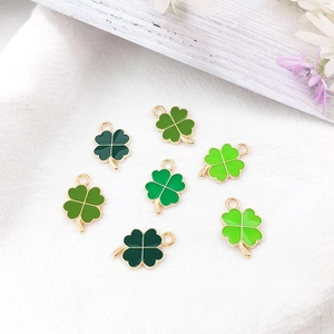 Detailed close-up of green clover enamel charms with gold edges for jewelry making