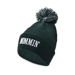 Detailed view of dark green knit beanie with MOMMIN embroidery and pom-pom