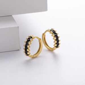 Detail of gold-plated silver huggie hoop earrings with micro-pave black zirconias