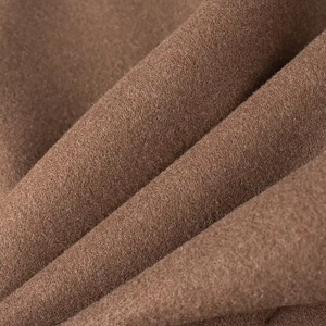 Gros plan sur la texture du tissu en laine marron montrant les détails de la matière