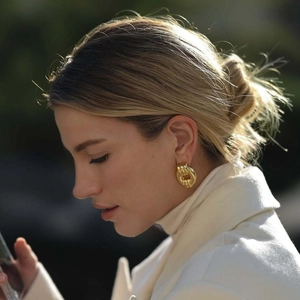 Orecchini a cerchio intrecciati in acciaio inossidabile placcato oro 18k su modella
