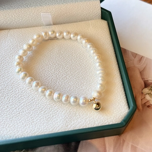 Macro shot of natural freshwater pearl bracelet with a 14K gold-filled bead in a box