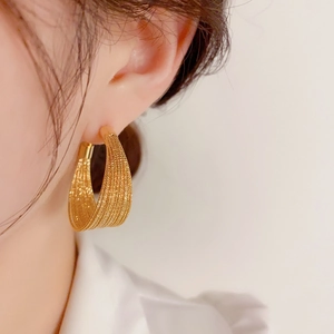Exaggerated S925 geometric gold mesh hoop earrings on model with a textured weave finish