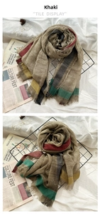 Detail of khaki wool scarf featuring colorful striped borders and natural fringed edges