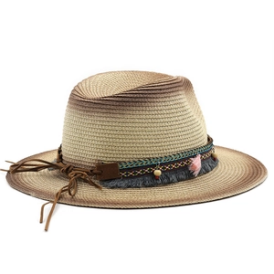 Detail of bohemian straw hat with colorful woven band and stylish pink fringe accents