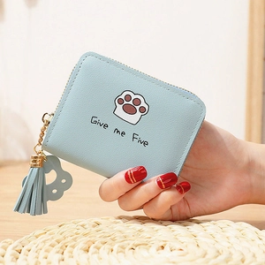 Détail du porte-monnaie bleu clair en similicuir avec empreinte de chat et gland