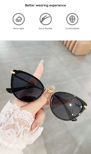 Detailed close-up of cat-eye sunglasses with black frame and golden bridge detail