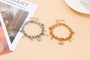 Détail de bracelets cœur multicouches en acier inoxydable avec perles sur fond pêche doux