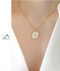 Detailed close-up of a gold star pendant necklace on a model's neck made of stainless steel