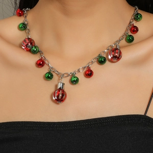 Detail of Christmas necklace with red and green bells and striped clear spheres on a silver chain