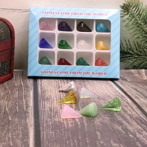 Detailed set of 12 pyramid natural stones in a striped blue gift box on wood