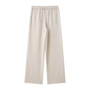 Detail of high-waist elastic waistband on beige striped wide-leg cotton trousers