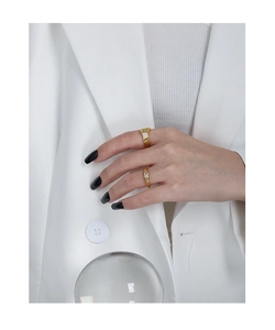 Close-up of two gold S925 silver rings with square zircon stones on model hand