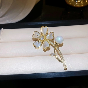 Vue détaillée de la broche fleur avec pétales en nacre, perle et diamants pavés