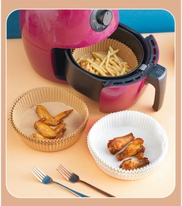 Round air fryer parchment liners in brown and white with fries and wings inside