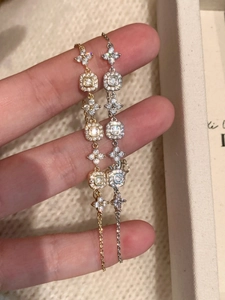 Close-up of gold and silver adjustable chain bracelets with cubic zirconia floral charms