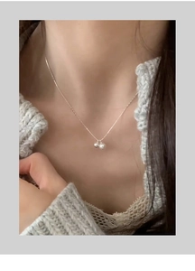 Detail of s925 silver necklace featuring a small silver bead and a natural freshwater pearl