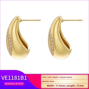 Detail view of gold teardrop earrings with brass material specs and zircon side accents