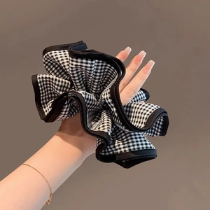 Chouchou rétro à carreaux noir et blanc avec tissu doux à volants tenu à la main
