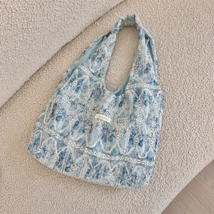Detail of blue lace floral tote bag with elegant embroidery on soft velvet background