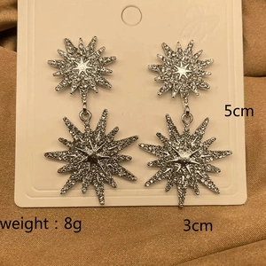 Detail shot of silver starburst earrings with size labels and rhinestone weight info
