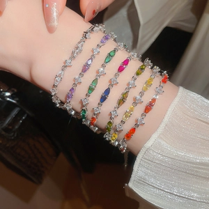Close-up of stacked marquise-cut colorful zircon bracelets on model wrist with silver finish