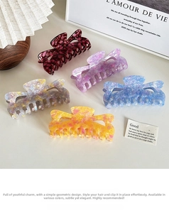 Flat lay of hollow heart acetate hair claws in five marble patterns and soft pastel colors