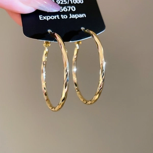 Detailed macro view of 14k gold plated twisted hoop earrings with geometric facets