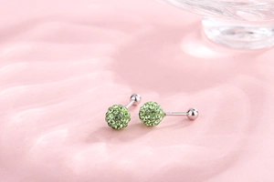 Macro shot of 925 silver light green pavé crystal ball earrings with screw back design