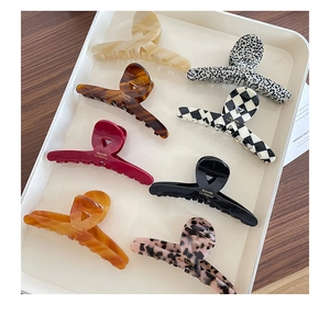 Detail of assorted tortoiseshell and checkered hair claws with gold logo branding