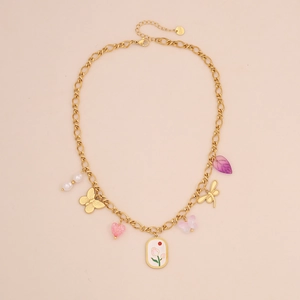 Dettaglio della collana in acciaio inossidabile dorato con ciondoli colorati a cuore e farfalla