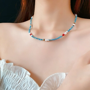 Close-up of a Neo-Chinese pearl necklace with colorful natural stones on a model's neck
