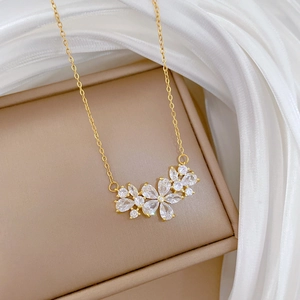 Detailed macro of gold flower pendant with sparkling crystals on a fine link chain