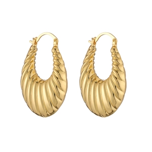 Detail view of thick gold hollow U-shaped earrings with spiral textured pattern