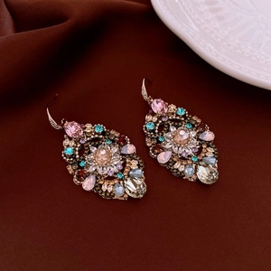 Detailed view of vintage heart pearl earrings with gold plating and colorful crystals