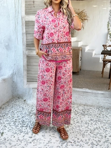 Détail d'un ensemble de vacances bohème avec chemise rose à fleurs et pantalon large