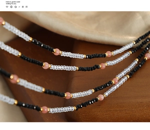 Macro detail of mixed natural stones and gold-plated titanium beads on the layered necklace