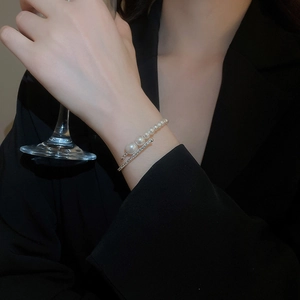Detail of layered wrap cuff bracelet featuring multiple pearls and sparkling rhinestones