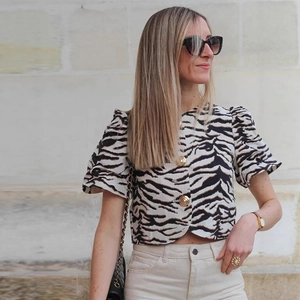 Retro zebra print crop top with puff sleeves and gold buttons, shown in outdoor setting