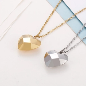Détail des pendentifs en forme de cœur facetté en or et argent sur des chaînes fines