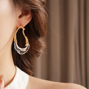 Close-up of model wearing 18k gold plated irregular drop earrings with clear resin details