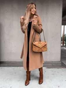 Detailed texture of camel wool coat with large lapel and matching waist belt buckle